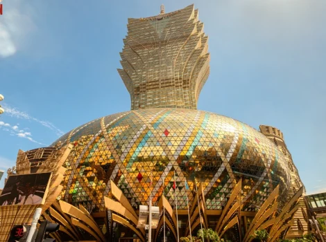 Iconic mirrored dome building with a tiered, crown-like tower rising above and glass triangle panels reflecting the city sky.