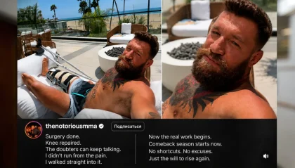 Bearded man with a knee brace relaxing on an outdoor lounge chair on a sunny terrace, beach in the background, tattoos visible on his chest and arm.